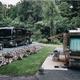 Two motorhomes parked on landscaped pads with gravel and surrounding woods — clear view of full‑service RV parking and site spacing (from Rates page imagery).