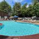 Clear, on‑site swimming pool with lounge chairs and the campground rec building in the background — good showcase of a campsite amenity (image appears on the site’s contact/gallery pages).