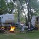 Campfire area between park-models/RVs with guests seated — shows typical campsite atmosphere and firepit facilities (Pictures page image).