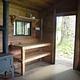 Harding River Cabin interior wood shelves, door open and stove