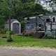 Seasonal RV/trailer site with deck, landscaping and surrounding trees — represents campsite accommodation (Pictures page image).