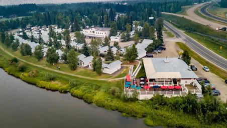 Aerial/drone-style view of the riverfront resort and cottages including the RV/campsite area and main facilities — provides an overall layout and context from above.