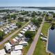 Aerial overview showing the RV rows, roads and large waterfront pond — clearly depicts overall campground layout (image used as the page hero on the property listing).