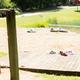 Panoramic beach/lake view with playground swings and dock area — shows the camp’s waterfront recreation area. Image is from the site’s Features & Facilities page header, confirming it’s on-property.