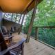 Deck seating view looking out over trees — shows guest outdoor amenity and relationship of cabins to wooded landscape (from site gallery pages).