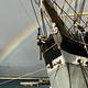 Historic Balclutha's figurehead with a rainbow and Golden Gate Bridge in background.