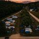 Dusk aerial of RVs and campsites with lighting — complementary evening view of the campground layout and guest areas visible on the homepage.
