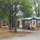 Deluxe cabin with adjacent RV visible, showing cabin exterior, patio and paved site area — demonstrates cabin accommodations offered at the KOA (ways to stay photo).