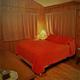 Main bedroom with wood paneling and bed — lodging page photograph depicting on-site sleeping accommodations (helps illustrate lodging options).