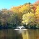 Pond with fountain and fall foliage — highlights scenic water feature on the property (resort areas page), useful for conveying site scenery.