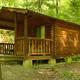Exterior view of a wood cabin on piers with a porch — clearly a campground cabin unit and good for lodging/gallery purposes (source: Photos page).