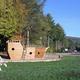 Playground feature shaped like a pirate ship on a grassy area with surrounding campground roads and trees — useful amenity shot from the property gallery.