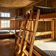 Sunlight shining on 3 bunk beds in a plywood cabin