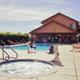 Pool and clubhouse view with hot tub in foreground and building behind — useful amenity photo matching the Amenities page showing on-site pool and guest facilities.