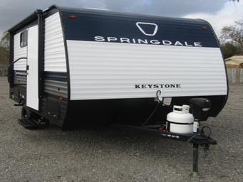 Clear image of a trailer on the dealership lot providing a close-up view of inventory and lot surface, useful to show the types of RVs sold and the outdoor display space.