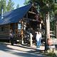 A park ranger and campground hosts in front of the rustic, log-structured Indian Creek Campground office.