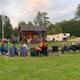 Outdoor stage with audience seated on campground lawn — documents on-site entertainment and common area (homepage slideshow at https://www.tippicanoe.com/).