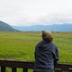 Visitor on porch of Little Dry Island Cabin looking out to grassflats and mountains in background