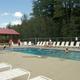 Ground-level pool photo with deck chairs and pavilion visible — useful detail of the campground’s swimming facility (gallery page).