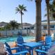 Clear, high-resolution photo of the pool area and surrounding deck/chairs with resort buildings visible — good image of on-site amenities (from the site's amenities images).