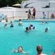 Photograph of the campground's outdoor swimming pool with campers and nearby RVs visible; image is from the site's header (2019 pool image) indicating it's a facility at this property.