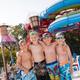 Pool area with large water slides in background and children in front — demonstrates the waterpark/waterslide attraction available on property.