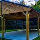 Large wooden gazebo/pavilion on concrete with picnic tables — a shared amenity on the campground grounds (Amenities page).