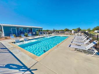 Well-lit pool and lounge area with surrounding buildings visible — shows on-site recreational amenity and matches the facilities/pool images on the amenities page.
