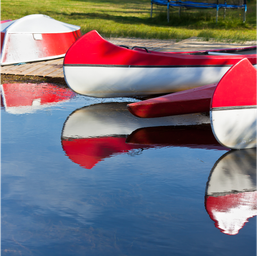 Canoes reflected in the water — depicts lakefront activity and scenery consistent with the campground's lake amenities.