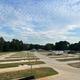 A rv park with a lot of grass and trees in the background