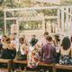 Outdoor dining workshop table set beneath oak trees at Serana