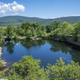 Aerial/overlook view of a deep quarry pond surrounded by trees and cliffs — distinctive landscape feature likely central to 'Quarry Ledge' campground and valuable as an overview scenic image.