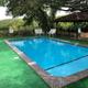 Swimming pool with fencing and pergola visible — clearly shows an on-site amenity (pool) and surrounding landscape; sourced from the resort 'Amenities' page.