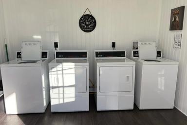 Interior photo of the laundry room with washers and dryers — documents on-site guest services and facilities.