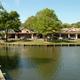 View of Camptown Center and adjacent pond from the site — shows community/facility buildings and on-site water feature useful for property gallery. Source: Home - Ocean Lakes Family Campground.