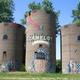 Three painted silo towers with 'Camelot' artwork — distinctive on-site landmark / property feature used on the campground website.