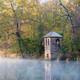 an old brick tower on the edge of a river