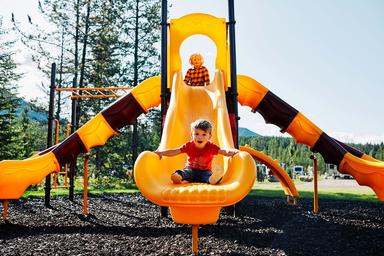 Playground slide with RV park visible in background — shows on-site family recreation facilities and proximity to the camping area as seen on the gallery.