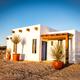 Clear exterior photo of one of the property’s white casitas set in the desert landscape; shows architectural style and setting used on the Casitas page.