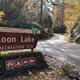View of Loon Lake Recreation Site entrance sign in the foreground with the entrance road in the background