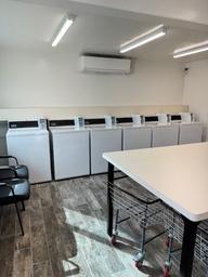 Interior photo of coin laundry with washers and folding table — shows an important guest amenity available at the campground; sourced from the property’s facilities images.