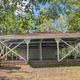 Covered picnic shelter/pavilion on grass with picnic tables — represents on‑site amenity and matches 'Amenities' page context.