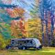 RV positioned on a grassy, tree-lined site with fall foliage visible — demonstrates an RV pitch and setting on the campground (IMG_5824 from the gallery).