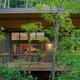 Frontal exterior of a cabin set in forested surroundings, good overall property view highlighting building design and site vegetation (used on the property’s landing page).