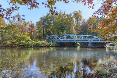 Scenic creek view with a footbridge on property — highlights the creekside setting referenced on the campground page and provides attractive onsite scenery.