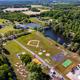 Aerial view of the campground grounds showing ponds, open fields, a baseball diamond and clustered facilities — good overall site/layout overview (from the property's Gallery page).