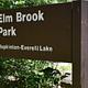 A close-up of the Elm Brook Park sign near the main entrance of the park.