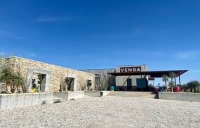 Exterior of the property’s Venga building with signage and approach area — helpful to show a public/guest-facing facility on the property (from Venga page).