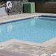 Clear photograph of the resort pool and paved patio area — labeled on the site’s North Amenities page and used to illustrate on-site recreational facilities.