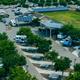 Daytime aerial panorama of the resort with clearly visible paved RV pads, landscaping, and adjacent roadway — from the RV Sites page (hero drone shot) showing site arrangement and access.